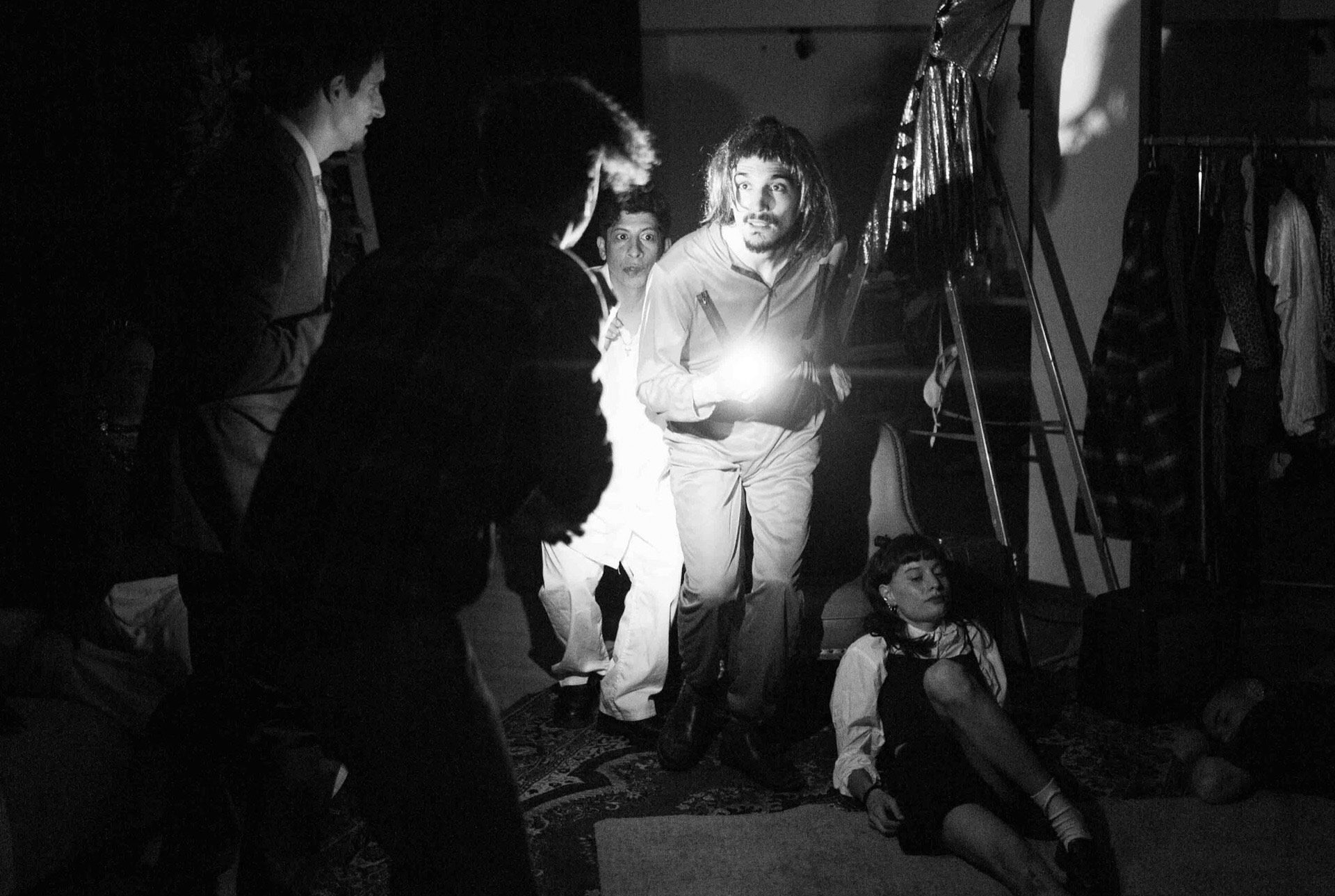 Actores del curso avanzado en una escena nocturna iluminada con linterna, en blanco y negro